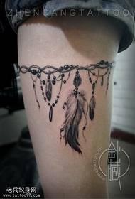 A woman's leg feather leg chain tattoo work is shared by the tattoo hall