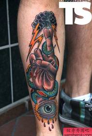 A creative hand snake eye lightning tattoo work on the leg