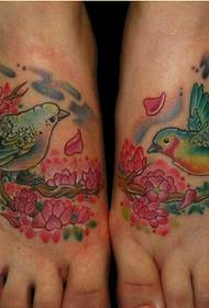 美しい足の美しい見ているカラフルな鳥の花の入れ墨の写真