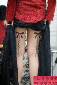 ljepote noge s prekrasnim uzorkom tetovaže luka i čipke