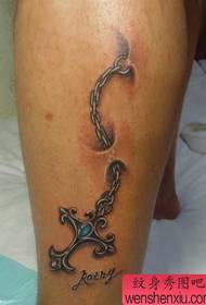 gražiai atrodantis tatuiruotės kryžius ant kabančios grandinės
