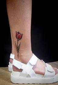 a flower tattoo pattern on the outside of the bare foot