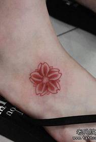 a small cherry blossom tattoo on the girl's instep