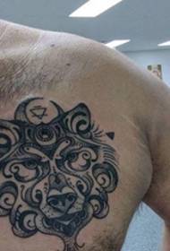 a beautiful black decorative style wolf tattoo on the male chest