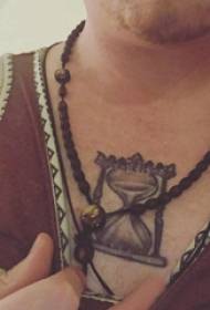 Tatuaggio a clessidra maschio sul petto foto tatuaggio clessidra grigio nero