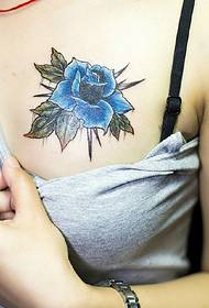 blauwe roze tatoet tatoet op 'e boarst fan it famke