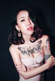 nobriedušas sievietes krūtis ar angļu un ziedu rokas tetovējumu