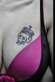 seksīga skaistuma krūtīs nēsājot vainaga tetovējumu