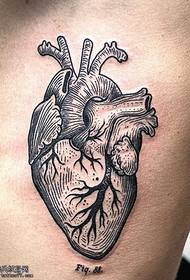 Peito cun patrón de tatuaxe de corazón palpitante