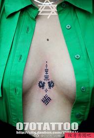 un petto di tatuaggio con lettere sanscrite
