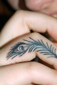 Pequeno padrão de tatuagem de penas de pavão no dedo da menina