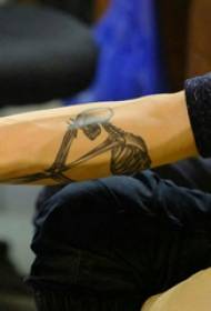 Bone tattoo seuntjie se arm op swartgrys been tatoeëermerk