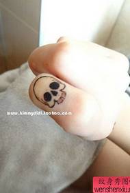 Woman finger creative skull tattoo work