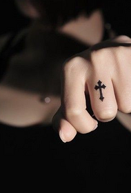 Female finger personality cross tattoo