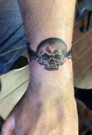 Skull tatuajea, mutil baten tatuaje argazkia hegoak besoan