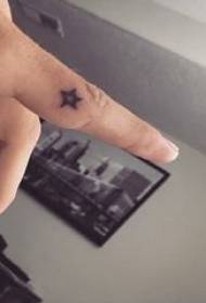 Velik petokraki zvezdniški tatoo moškega študentskega prsta na črni sliki petokrake tetovaže zvezd