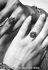 Compass tattoo pattern on couple fingers
