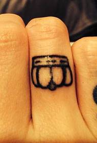 Finger wearing a crown on a tattoo