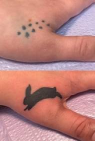 Tattoo finger covering girl finger on black rabbit tattoo overlay picture