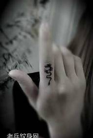 Lite drage tatoveringsmønster på fingeren
