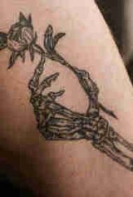 Getatoeëerde dij mannelijke jongen dij op bloem en vinger bot tattoo foto