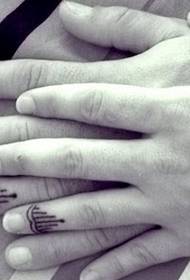 Acople dedos com uma tatuagem particularmente agradável do totem