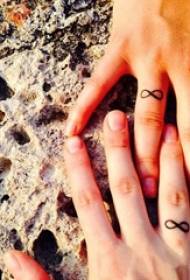 Įvairūs literatūriniai ir maži švieži ir kupini prasmės porų merginų pirštai ant žiedo tatuiruotės modelio