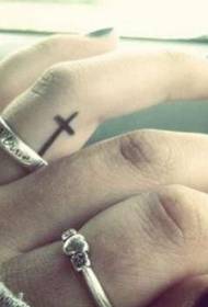 Cross pattern tattoo between fingers