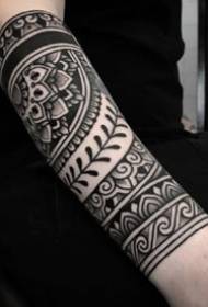 Black totem flower arm tattoo artwork on the arm