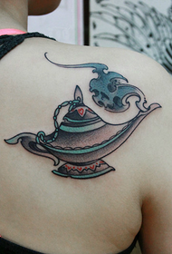 Aladdin's lamp tattoo on the shoulder of a beautiful woman
