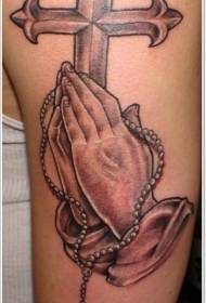 Татуировка с изображением большого креста и молящейся руки