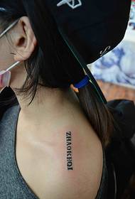 Vienkāršs angļu valodas vārds tetovējums uz meitenes pleca