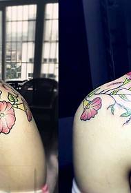 Teste padrão bonito da tatuagem da flor nos ombros de um menino da personalidade