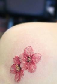 여자의 어깨 아래로 떨어지는 꽃잎 문신 문신
