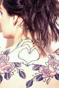 Beautiful girl with flower and heart tattoo on her shoulder