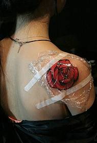 Uzorak tetovaže crvene ruže ispod mirisnog ramena vrlo je ženstven