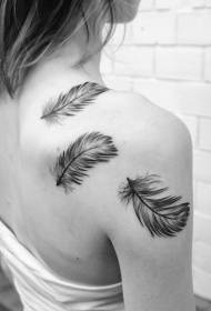 Girl's shoulders with flowing black and white feather tattoo pattern