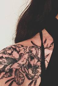 Emakume beltzaren dama sorbalda lorearen tatuaje argazkia
