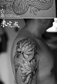 Na ramenu realističan tradicionalni uzorak tetovaže lotosa i zmija