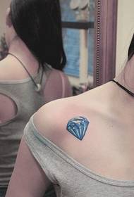 Picture of a woman's shoulder colored diamond tattoo work