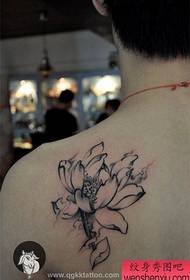Na ramenu tetovaža lotosa s tintom