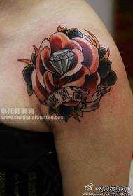गुलाब और हीरे के टैटू पैटर्न के साथ महिला कंधे