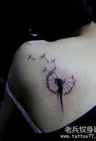 a delicate dandelion tattoo on the shoulder of the girl