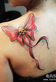 A beautiful colored bow tattoo pattern on the shoulder of a girl