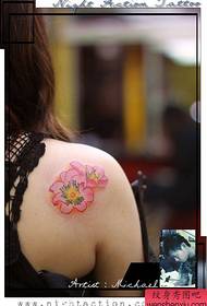 美麗而精緻的粉紅色花卉紋身圖案在女孩的肩膀上