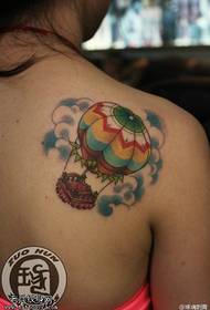 Әйелдің иығына түрлі-түсті ыстық әуе шарымен татуировкасы