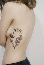 beautiful heart-shaped flower arrangement tattoo picture on the side ribs of the girl