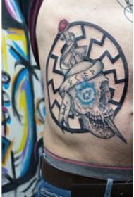 Tatueringssidahalja manlig pojkesida midje dolk och skalle tatuering bild