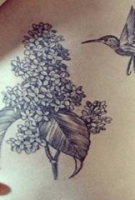 meitene jostasvietā melni pelēka minimālisma līnijas zieds ar kolibri tetovējuma attēlu