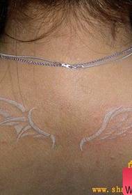 La mujer lleva un patrón de tatuaje de alas blancas